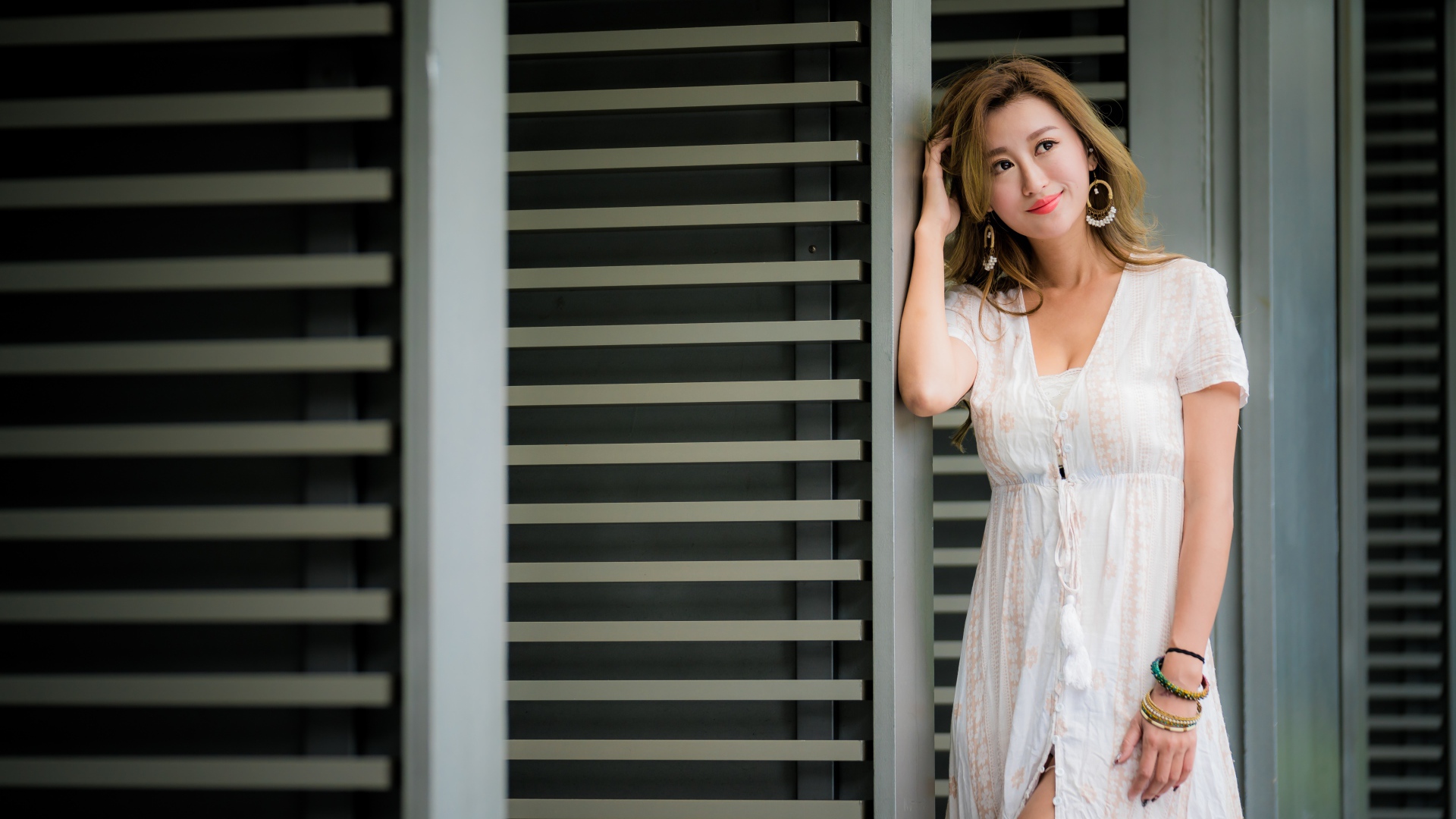 Красивая девушка азиатка в платье стоит у дверей