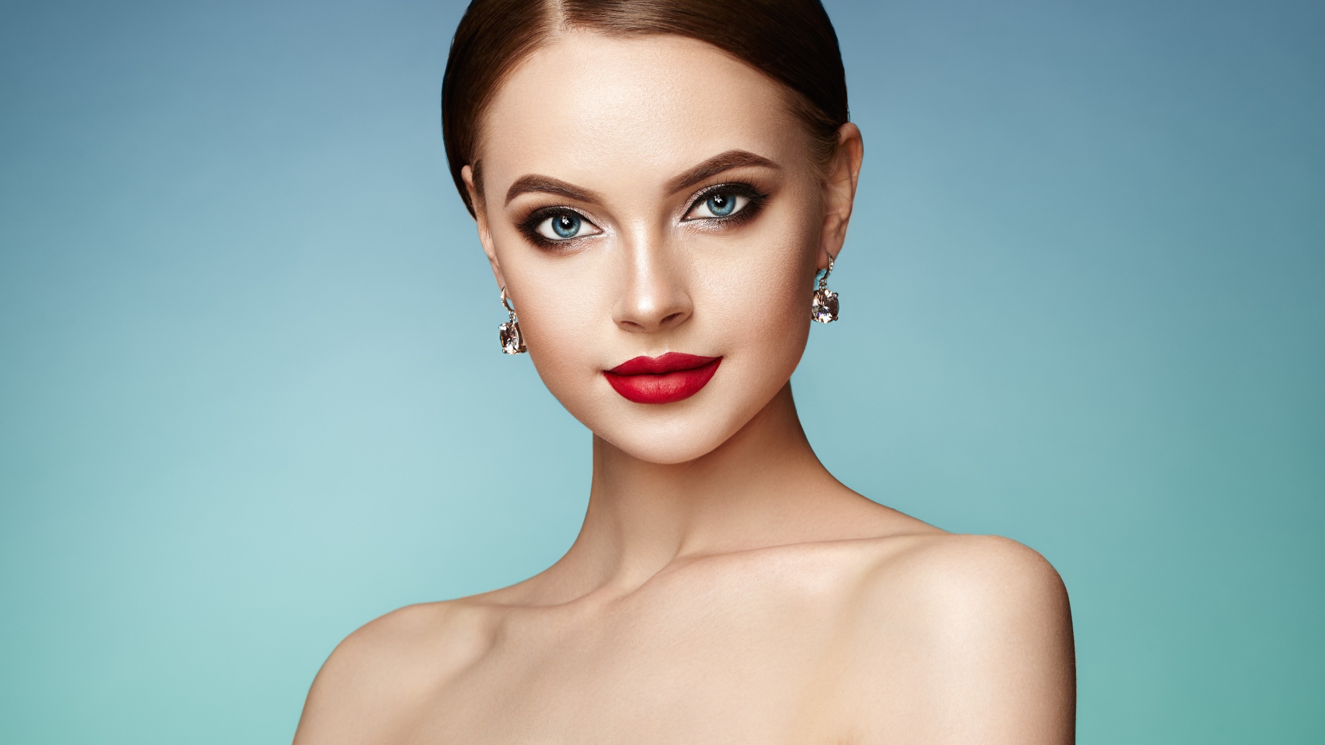 Красивая голубоглазая девушка с накрашенными губами и серьгами в ушах