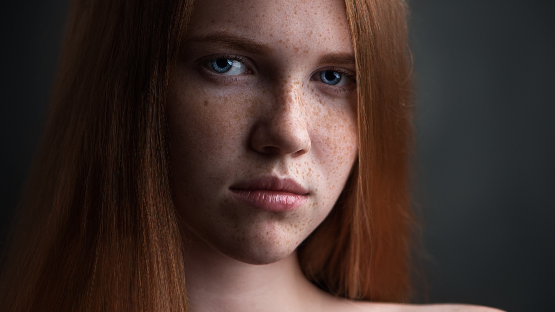 Красивая голубоглазая рыжеволосая девушка с веснушками