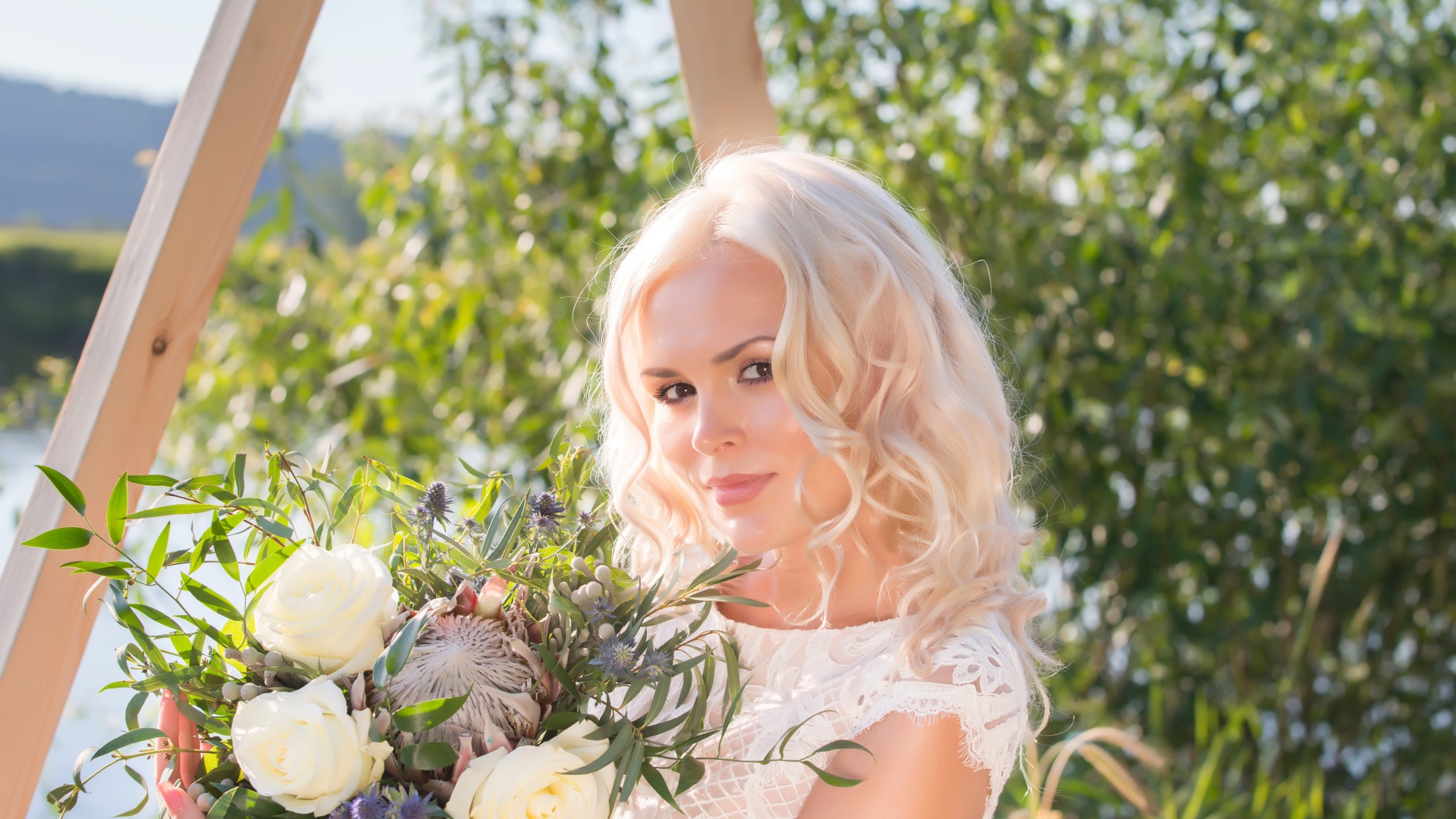 Красивая кареглазая блондинка с букетом в руках 