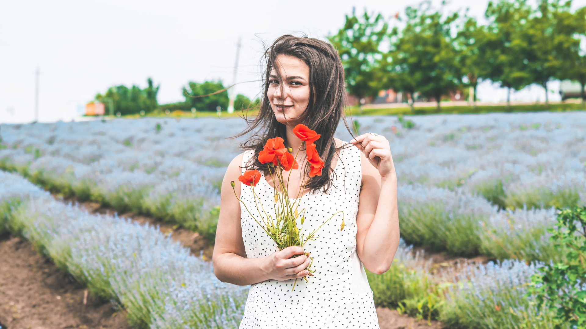 Красивая девушка в платье с букетом маков