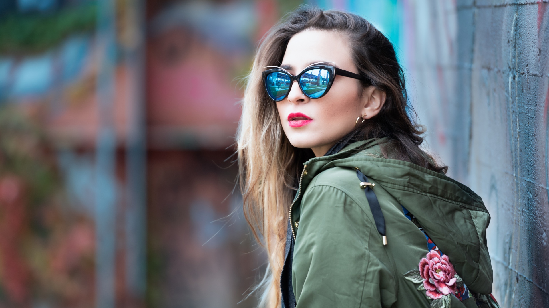 Красивая девушка в куртке и солнечных очках