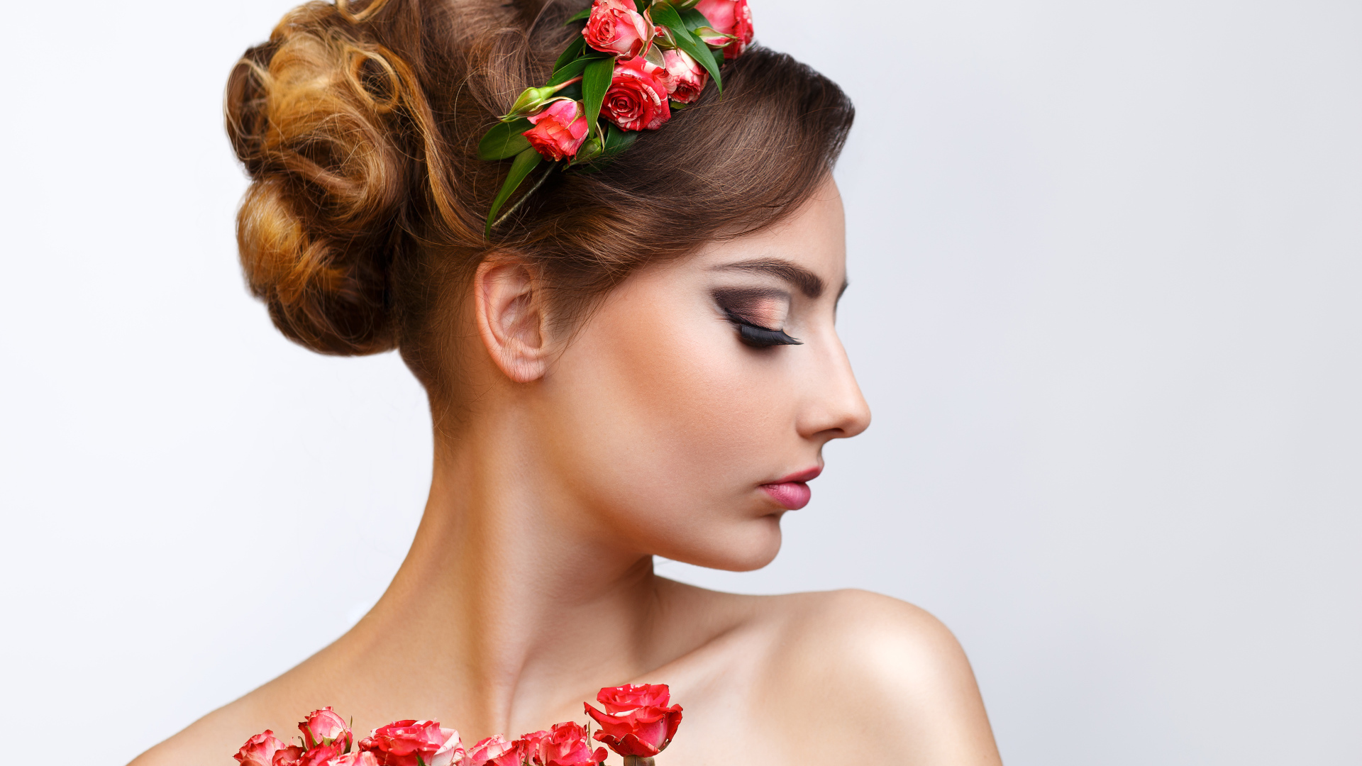 Красивая девушка с прической и венком из роз в волосах 