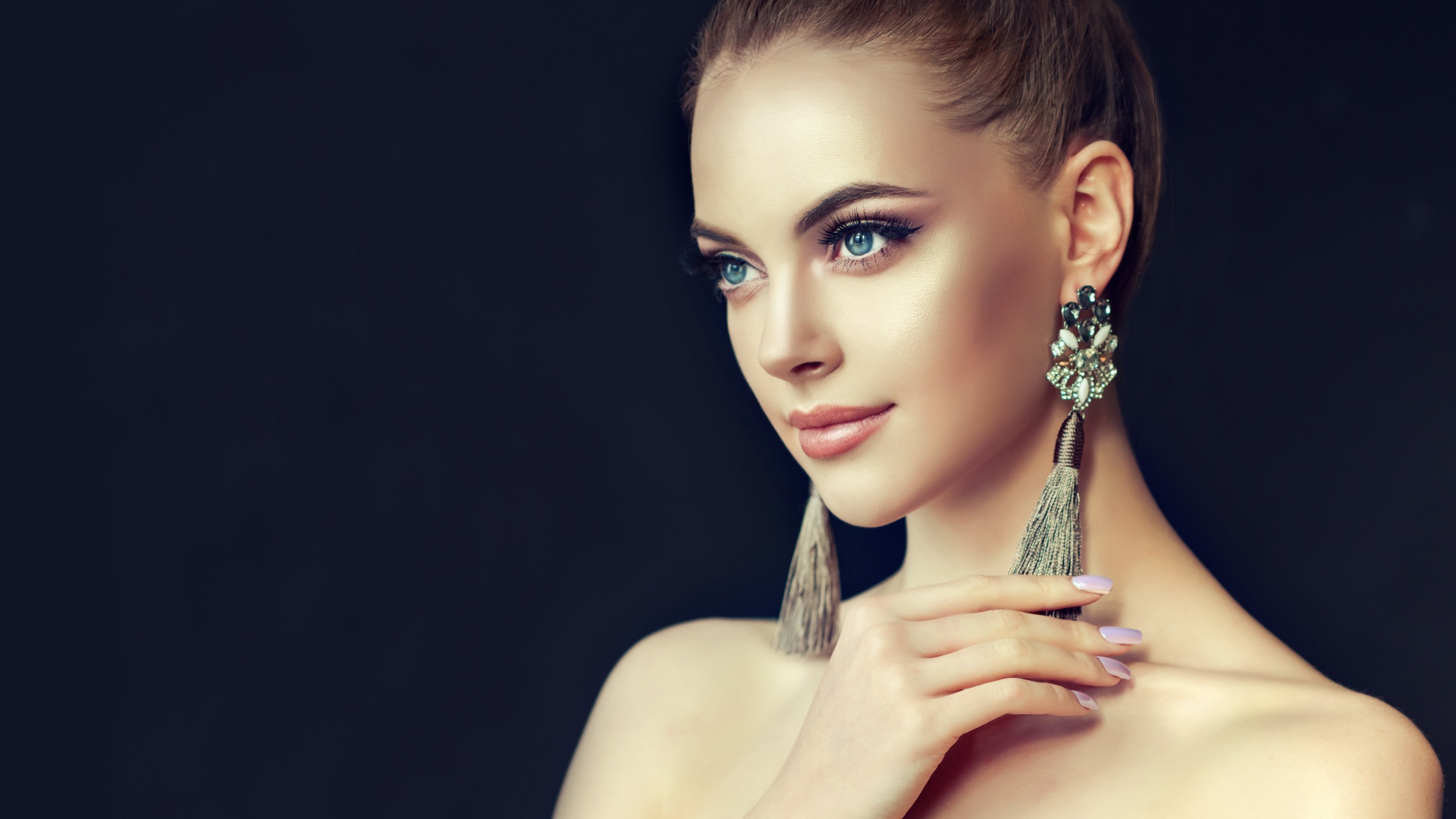 Красивая девушка с серьгами на черном фоне