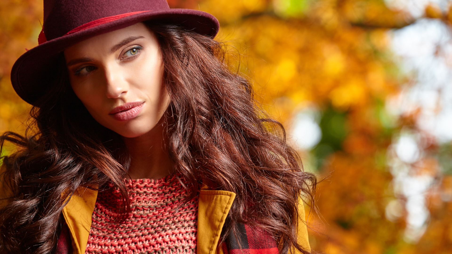Красивая длинноволосая девушка в шляпе осенью