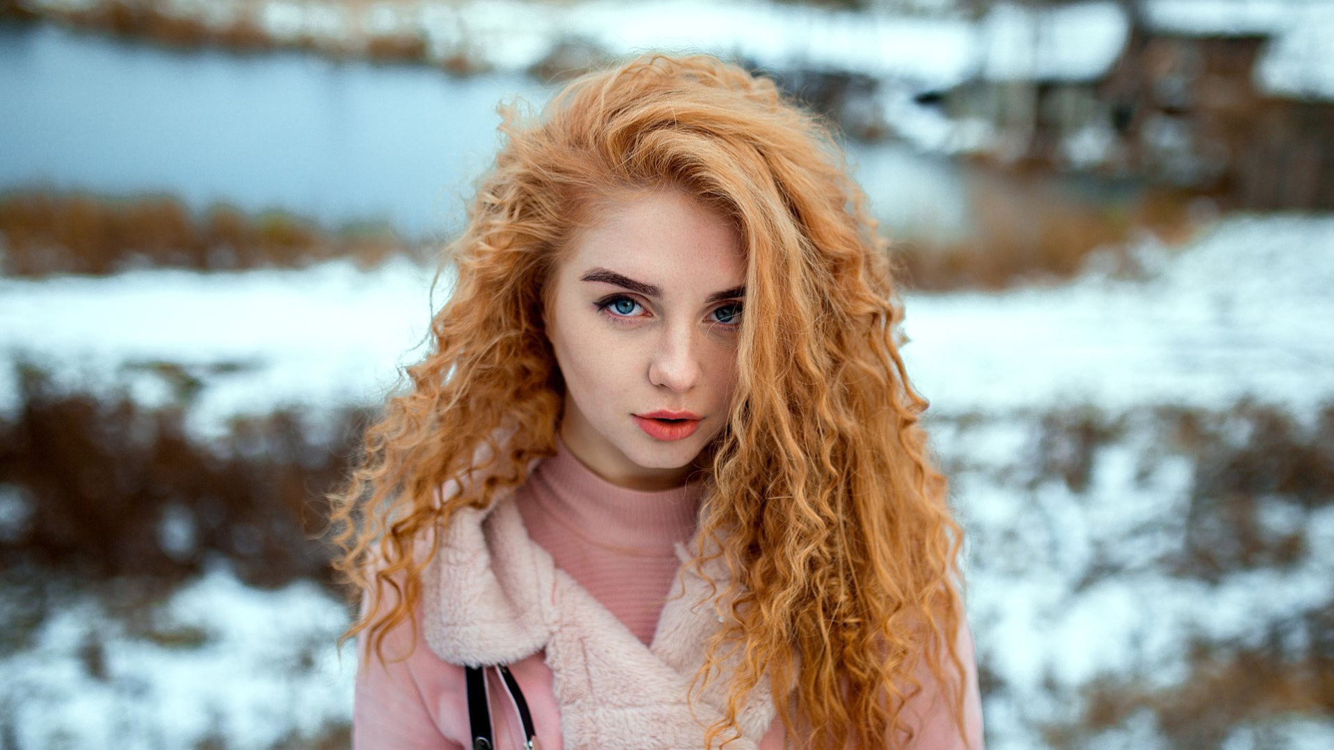 Красивая рыжеволосая девушка с голубыми глазами зимой