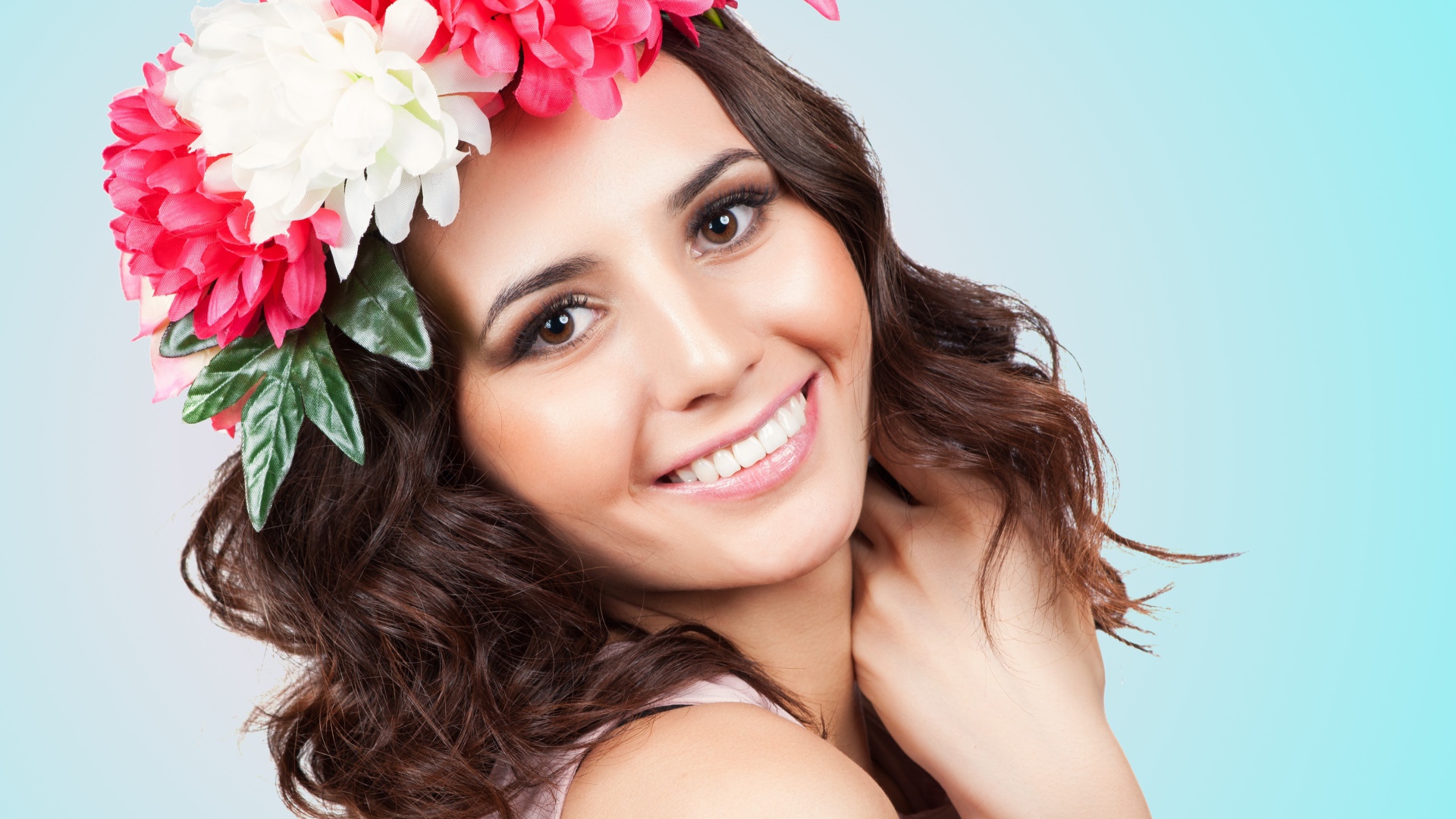 Красивая улыбающаяся девушка с венком на голове на голубом фоне