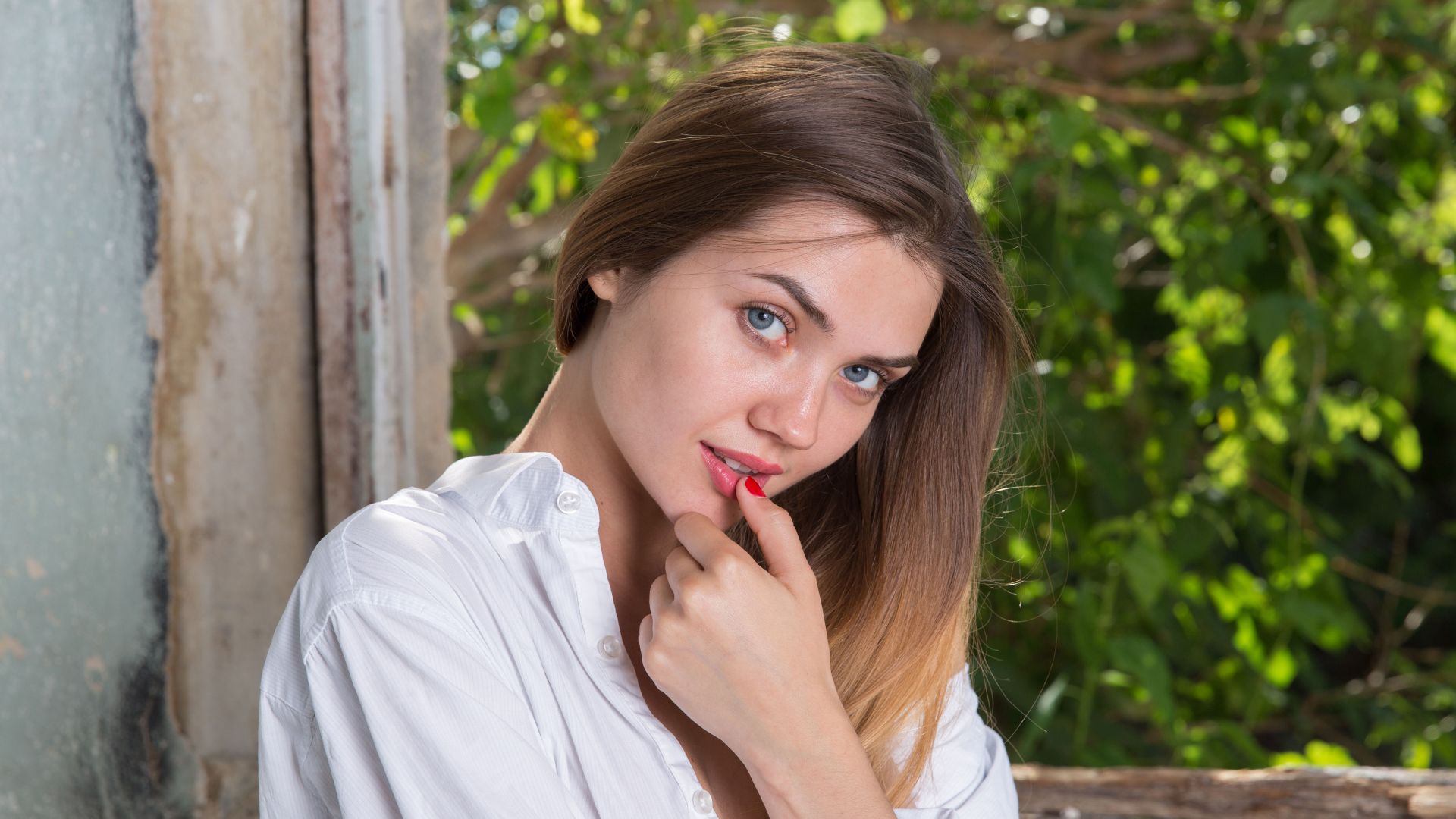 Красивая нежная девушка с серыми глазами с пальцем у рта