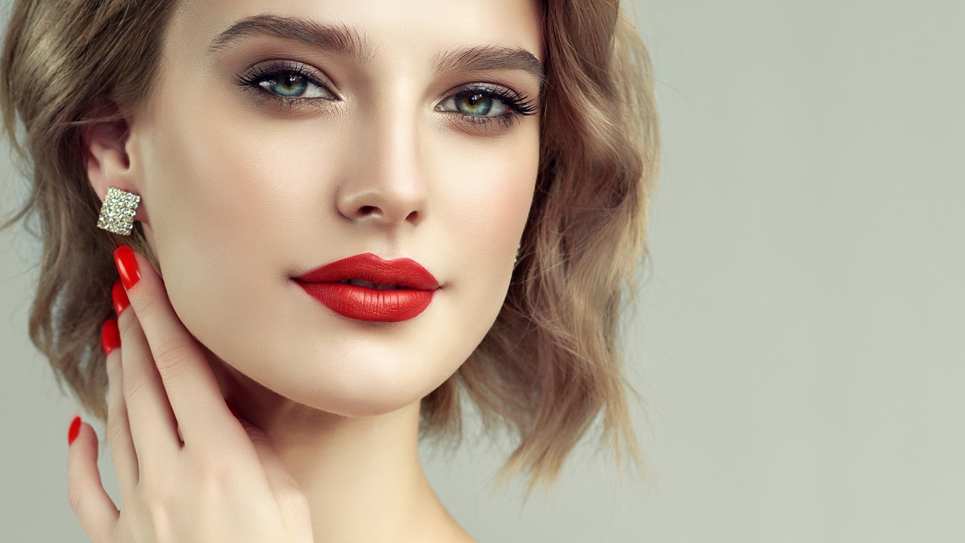 Лицо девушка с красивым макияжем на сером фоне