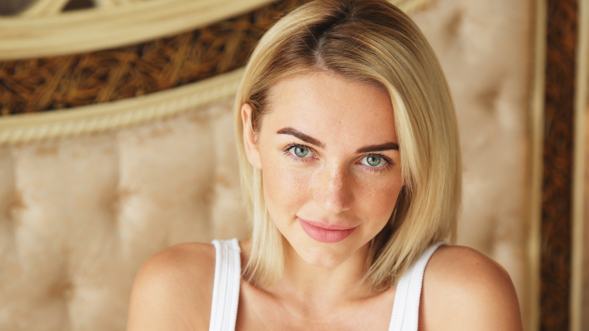 Нежная блондинка с зелеными глазами в белой майке