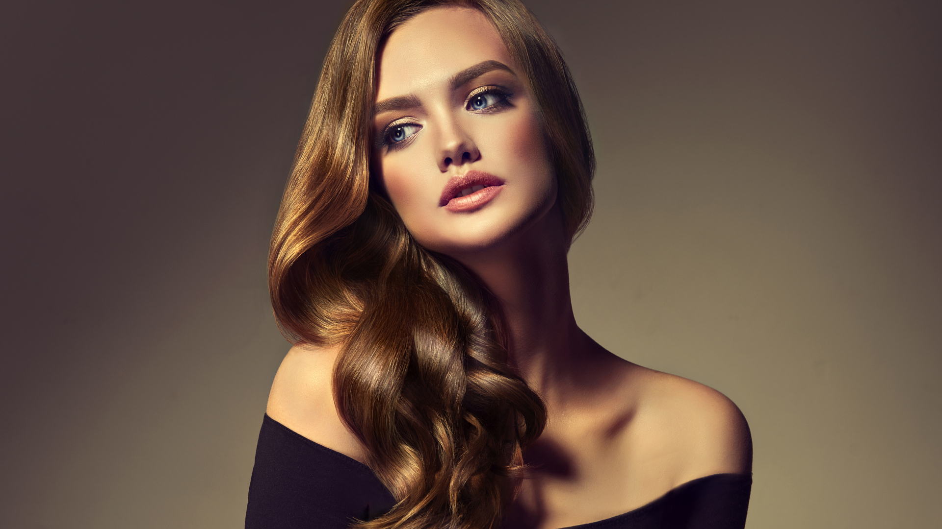 Нежная голубоглазая модель с длинными волосами на сером фоне