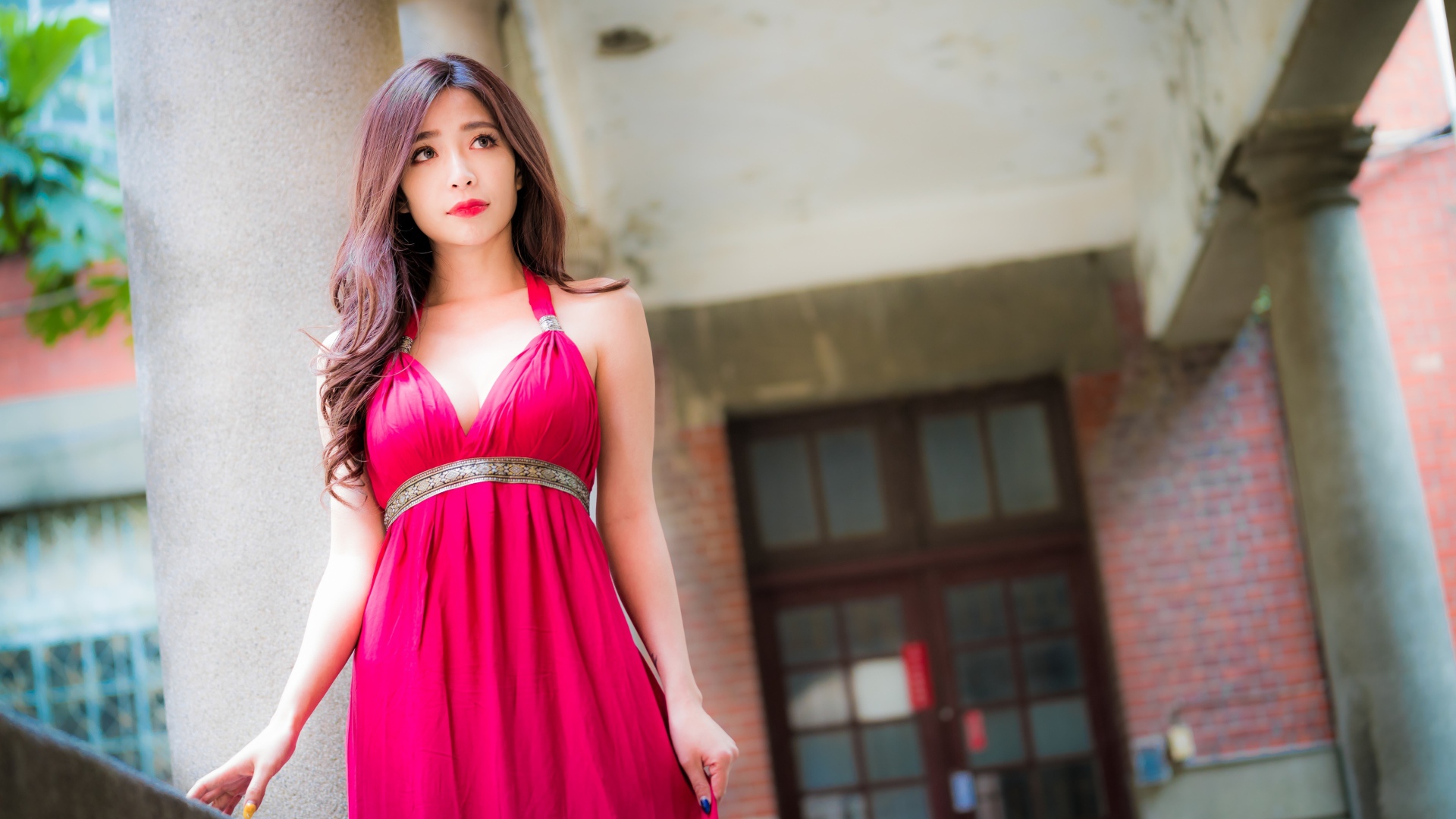 Девушка в красивом розовом платье у здания