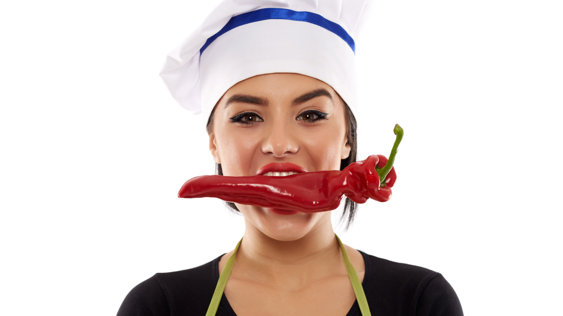 Девушка в шапке повара с красным перцем во рту на белом фоне