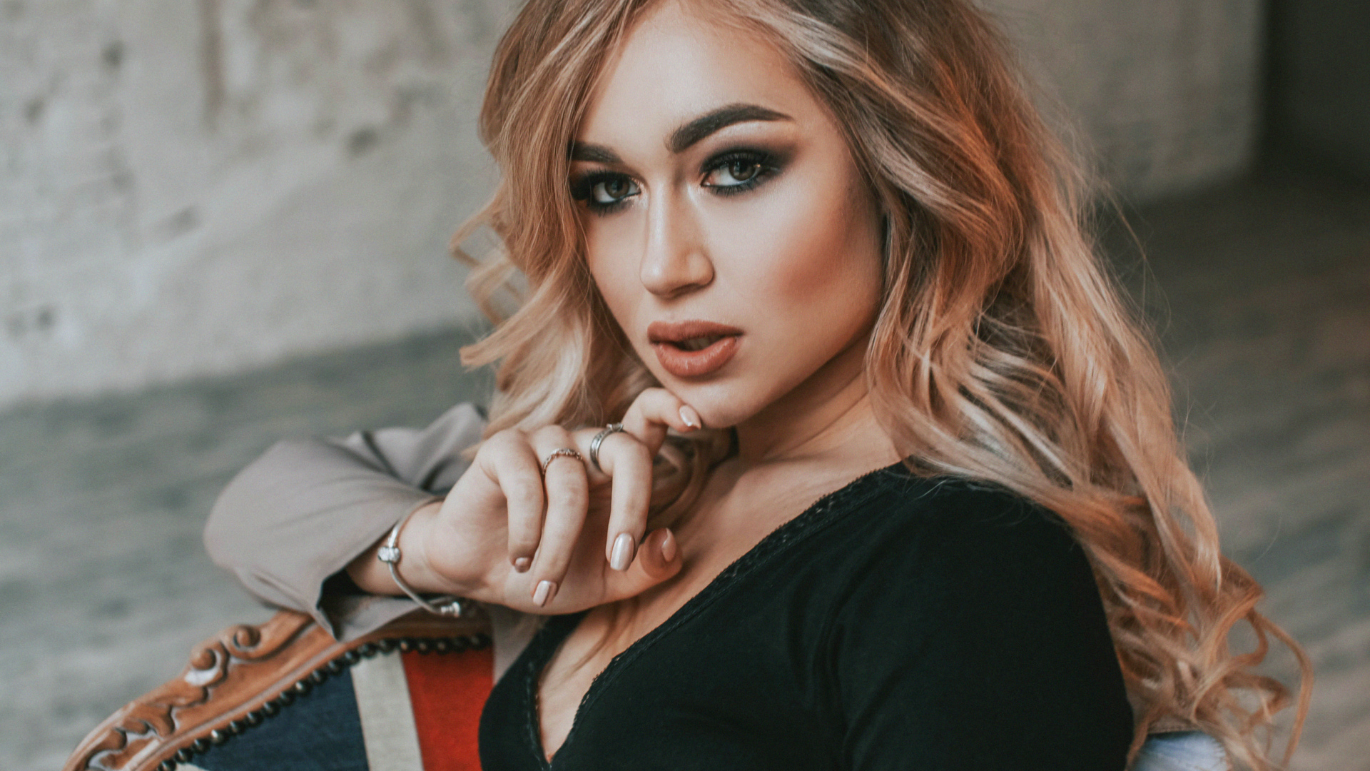 Горячая девушка с макияжем сидит на стуле