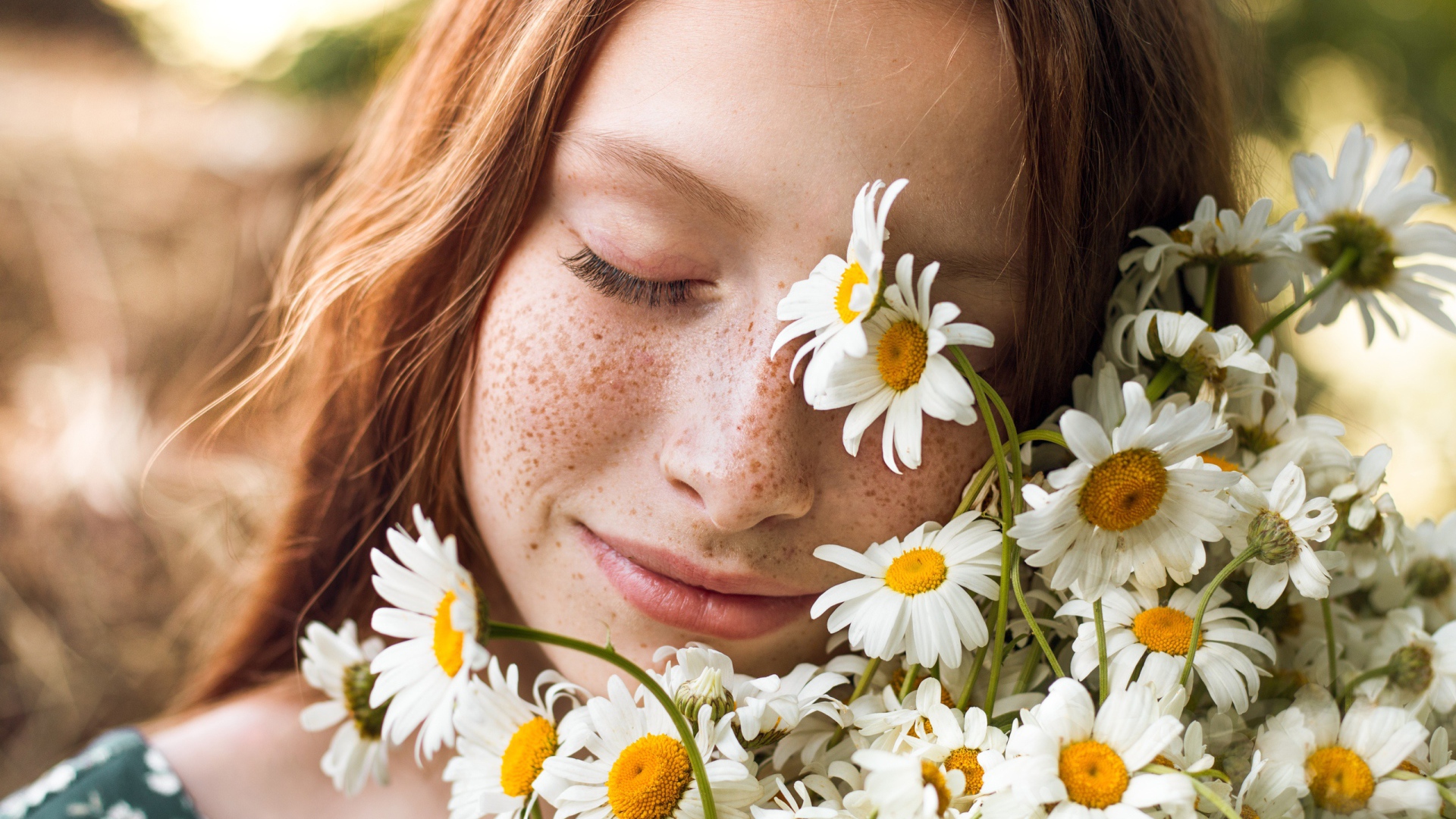 Рыжеволосая девушка с букетом ромашек