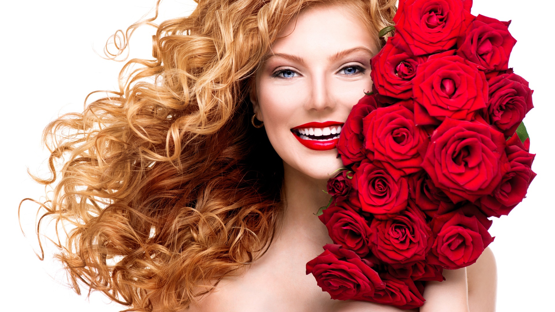 Улыбающаяся голубоглазая рыжеволосая девушка с букетом красных роз 
