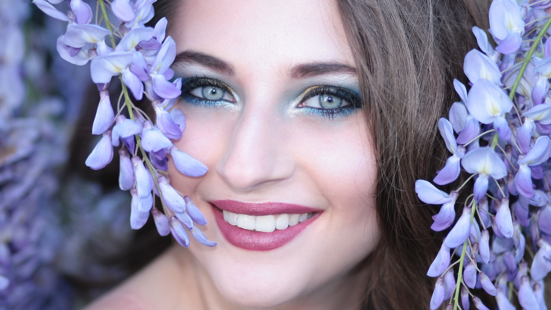 Улыбающаяся девушка с цветами глицинии
