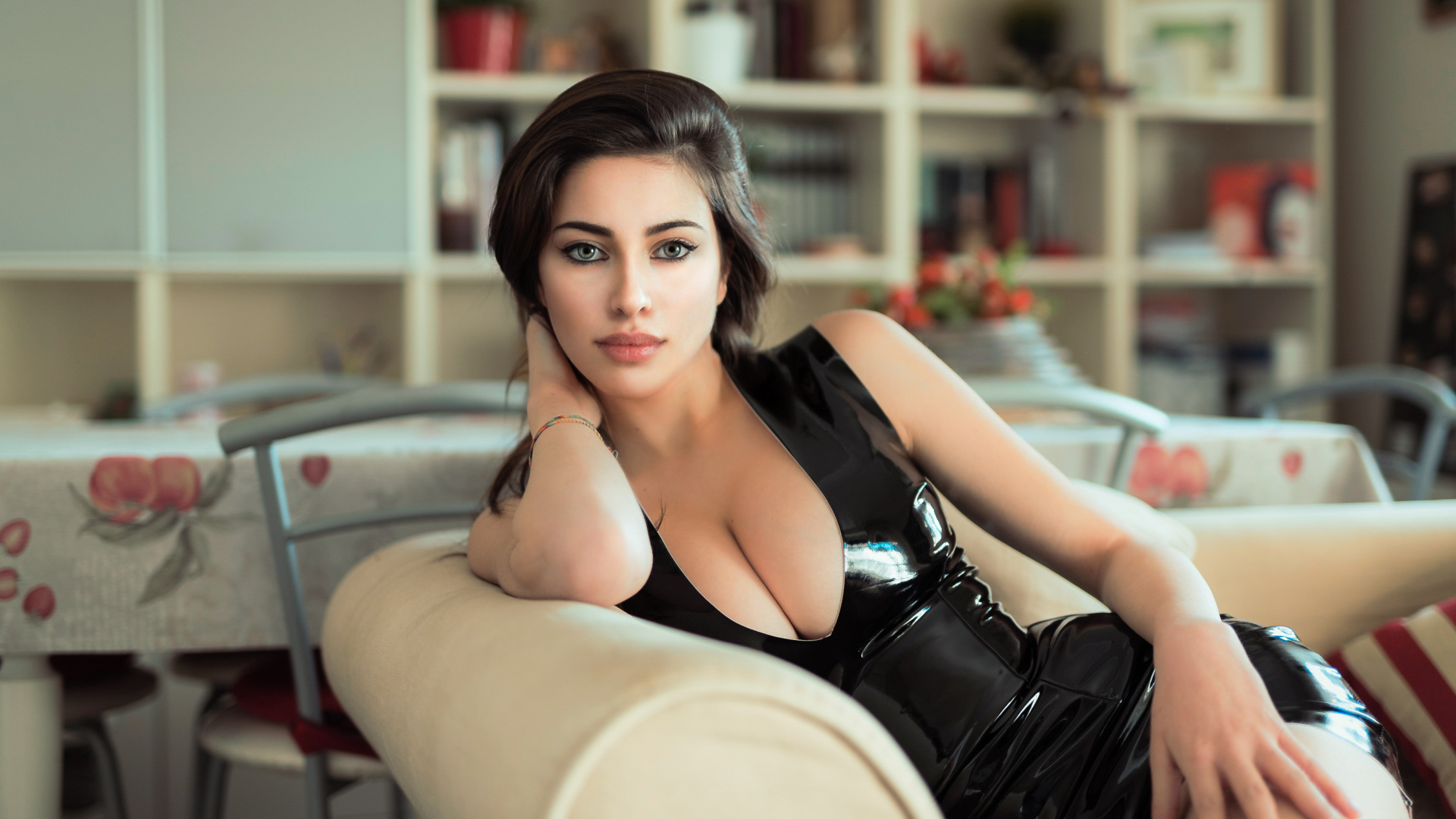 Стильная модная девушка в черном платье на диване