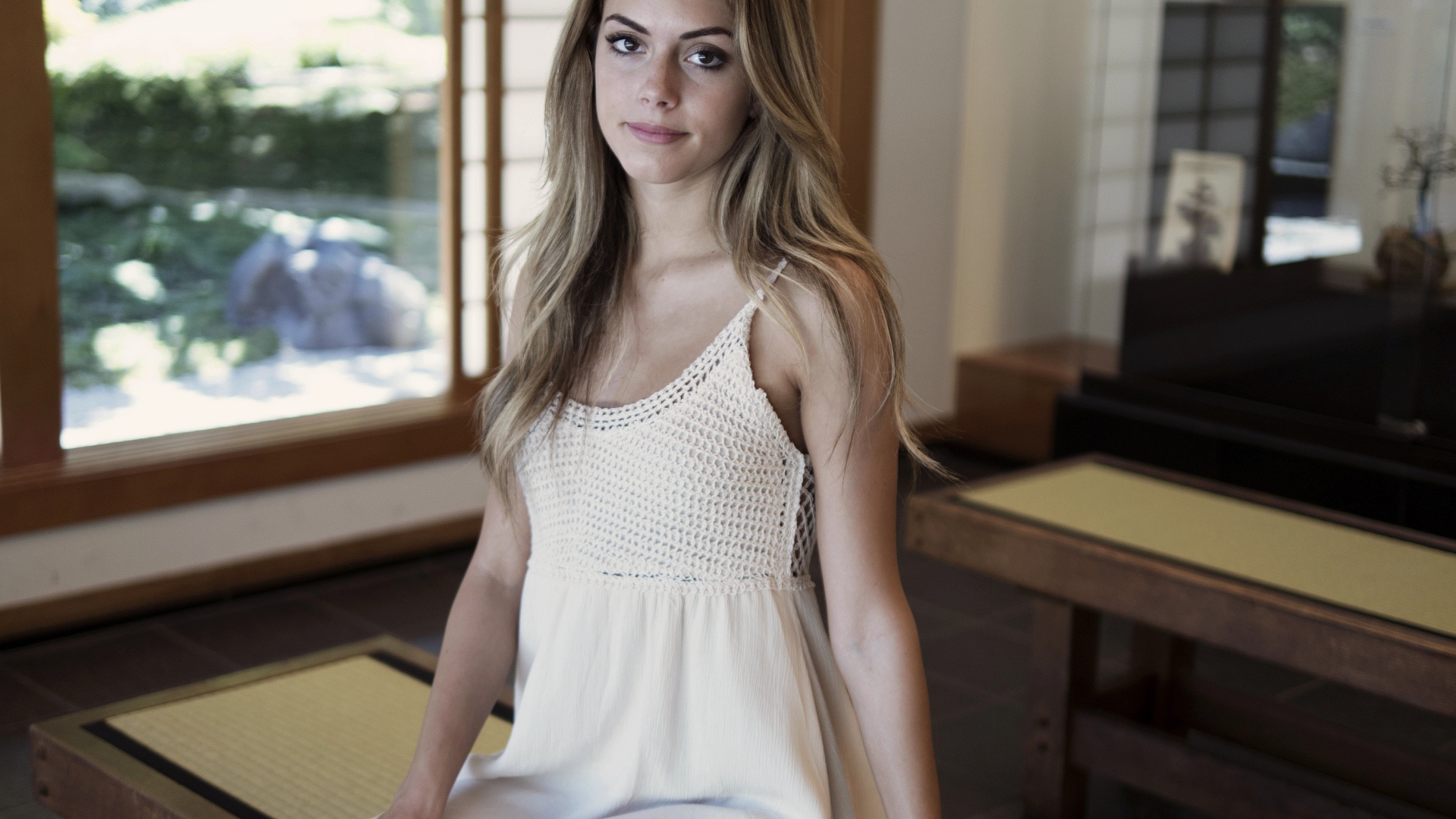 Девушка в белом сарафане сидит на лавке 