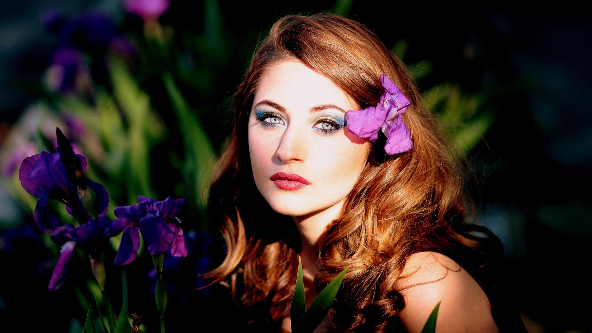 Молодая девушка с фиолетовым цветком ириса в волосах