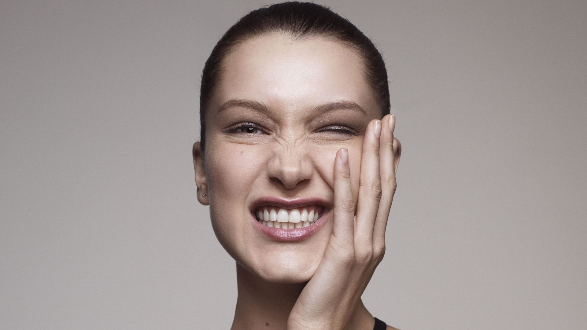 Модель Белла Хадид корчит гримасы на сером фоне