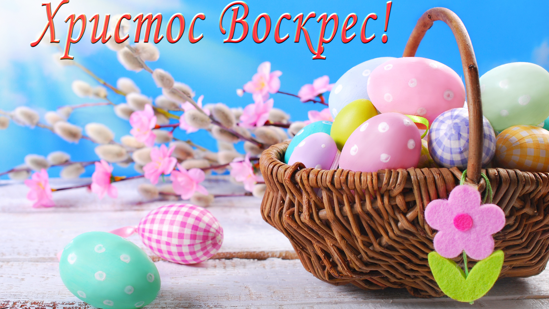 Корзина крашеных яиц на голубом фоне с надписью Христос Воскрес! 