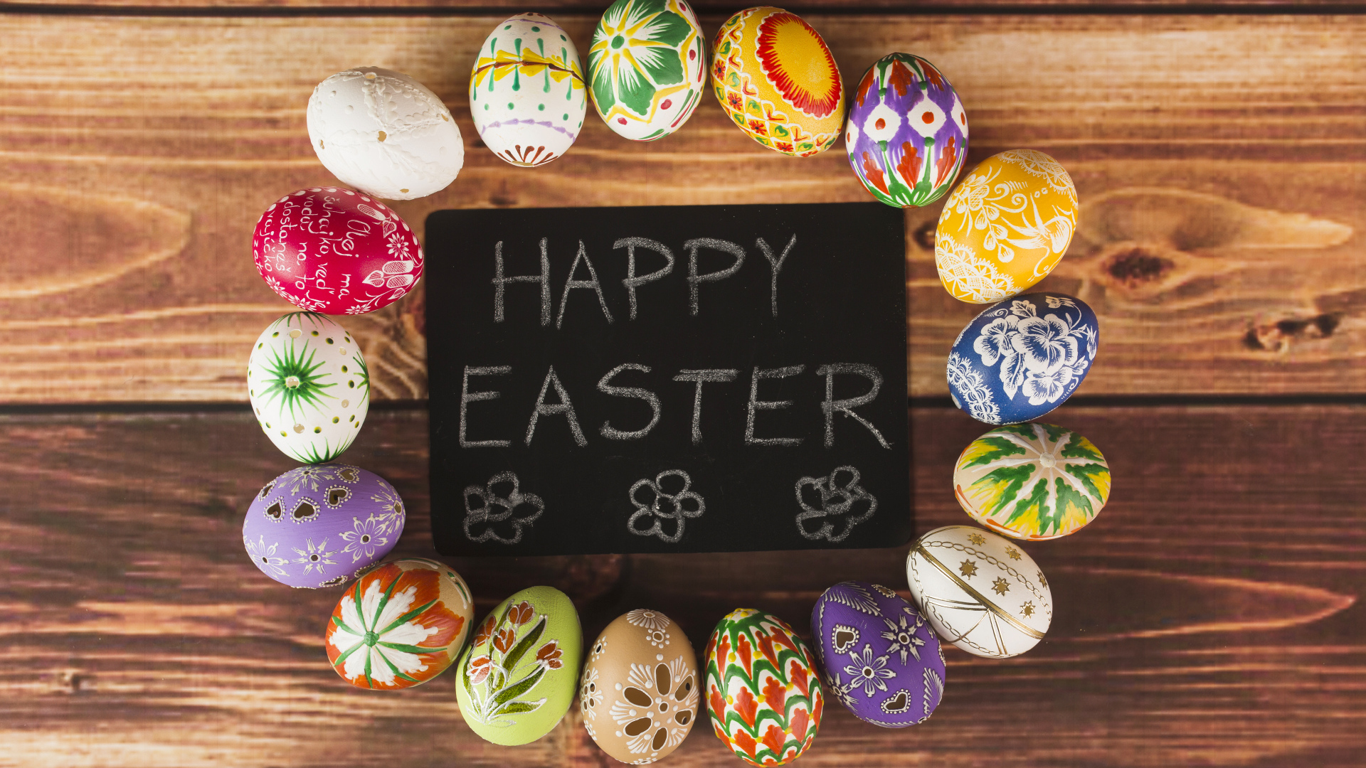 Надпись на английском Счастливой Пасхи на столе с крашеными яйцами