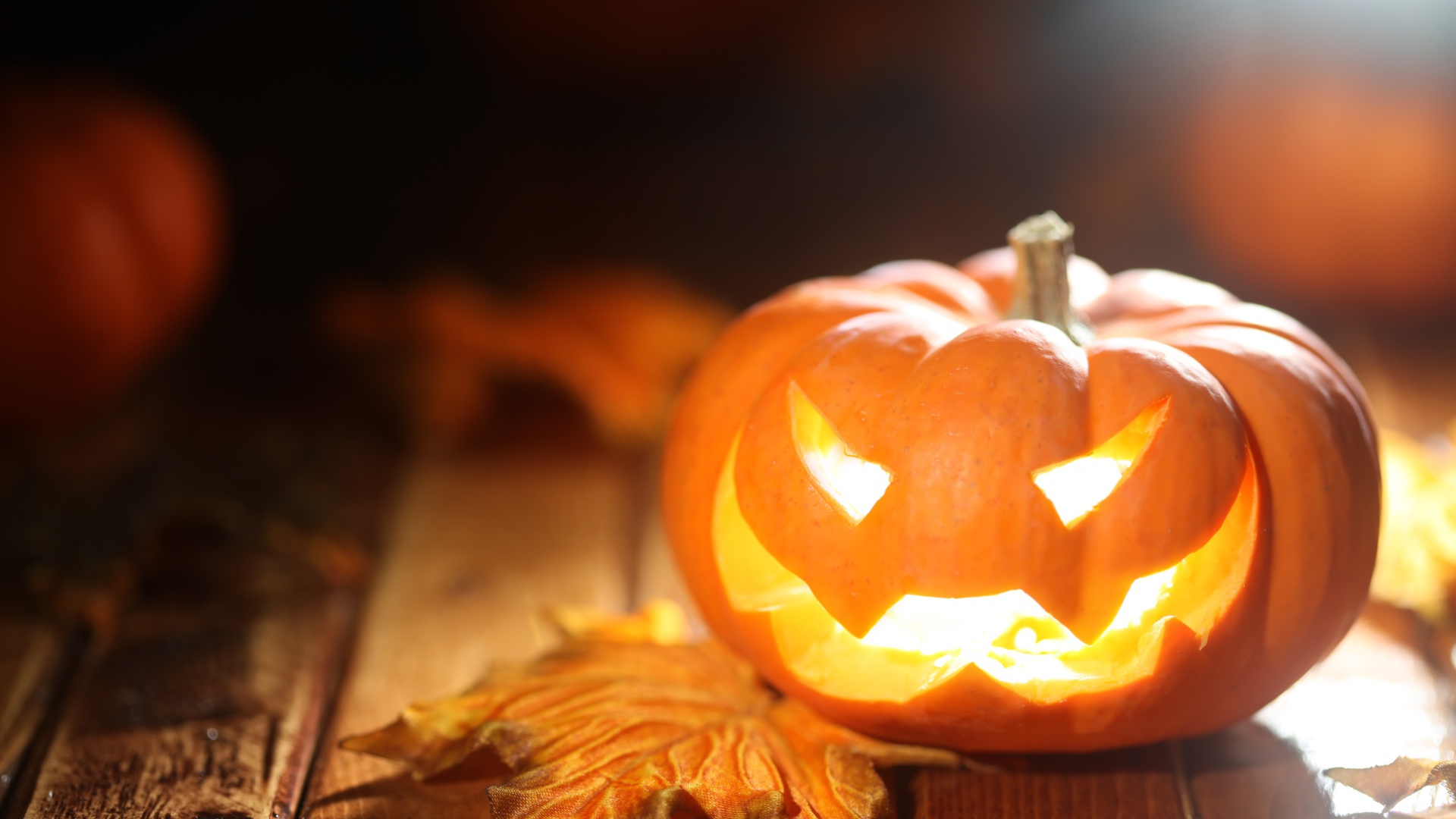 Светящаяся тыква на столе на Хэллоуин