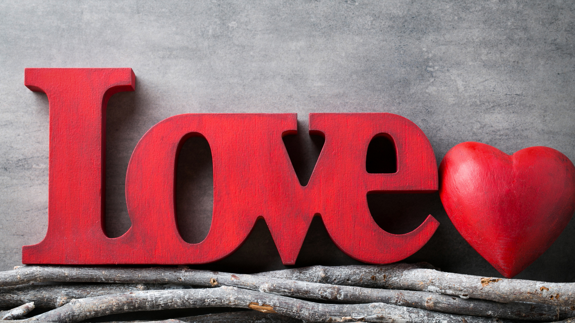 Большая надпись любовь на английском на фоне серой стены 