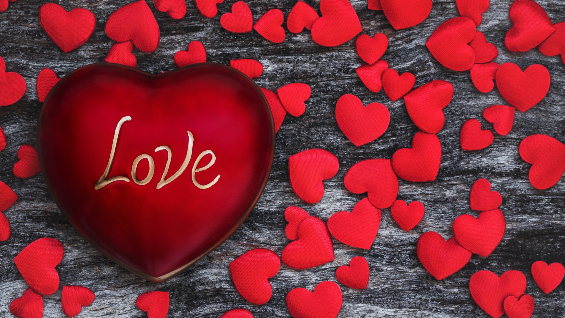 Большое красное сердце на деревянном фоне с маленькими сердечками