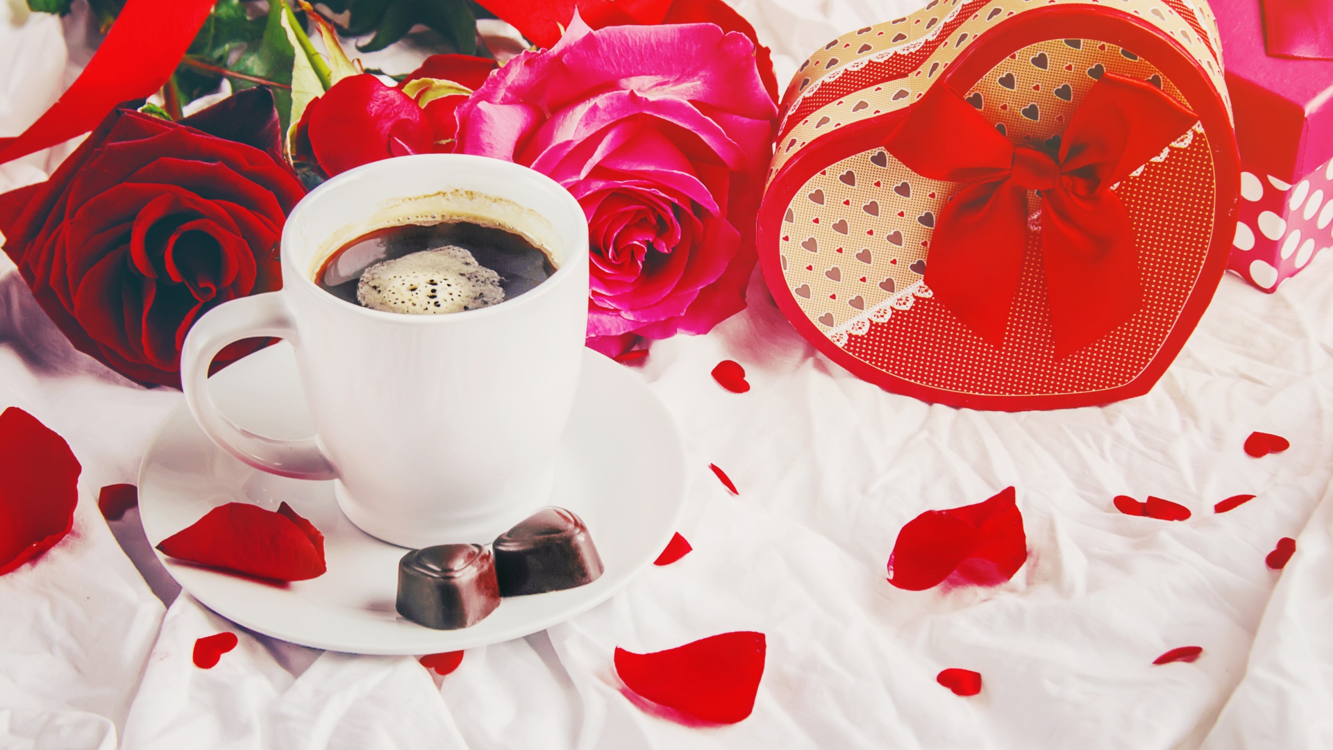 Коробка в форме сердца на белой ткани с чашкой кофе и розами