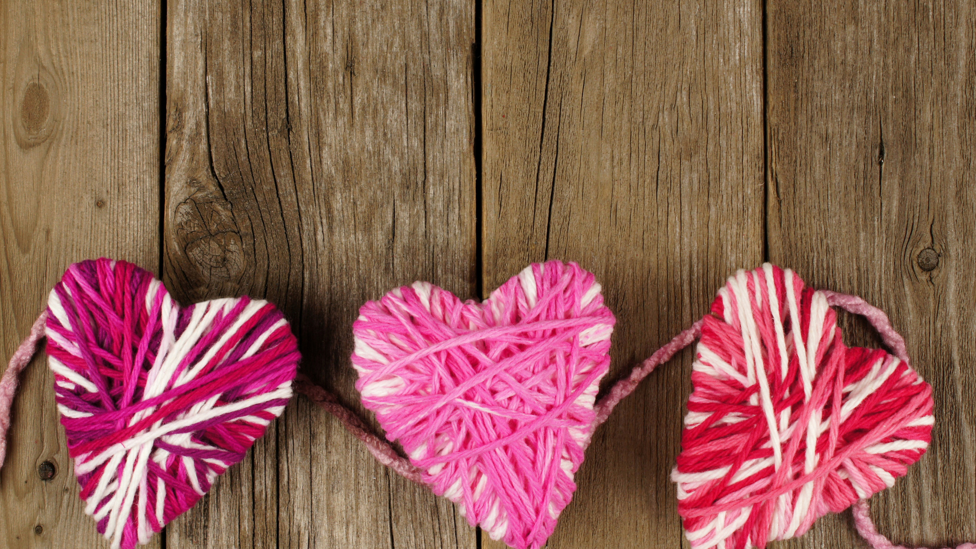 Сердца из ниток на деревянном столе