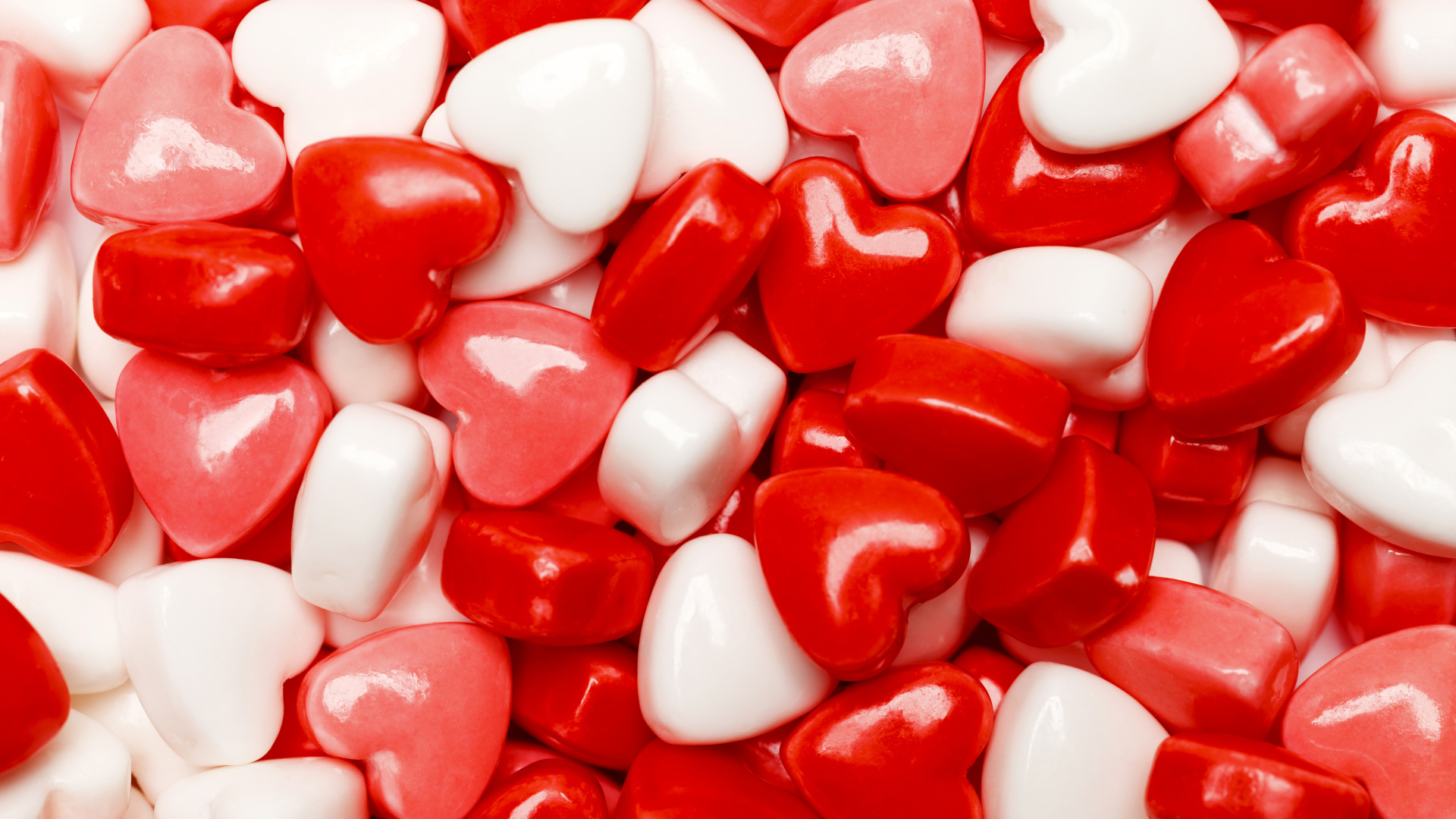 Много разноцветных конфет в форме сердца крупным планом