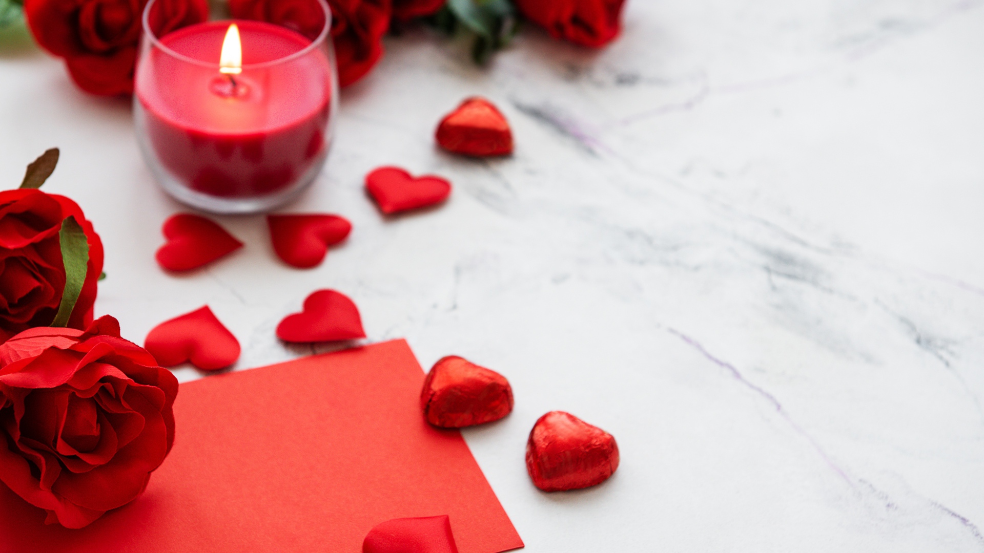 Красные сердечки, зажженная свеча и розы для любимой