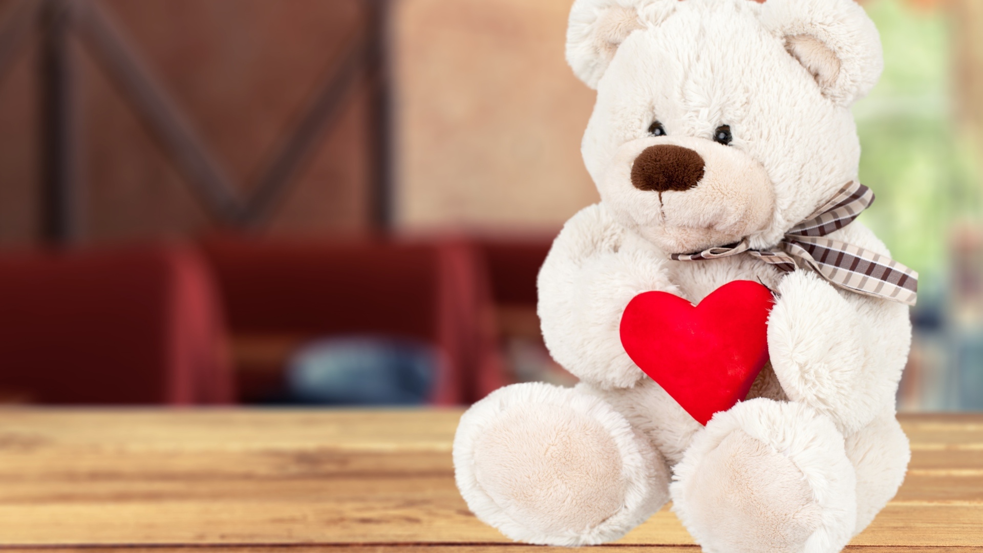 Белый плюшевый мишка с красным сердцем