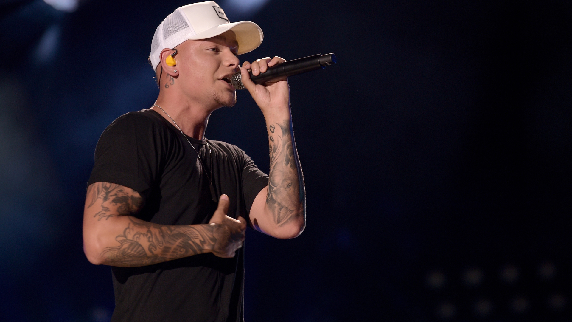 Американский кантри певец Кейн Браун с микрофоном на сцене