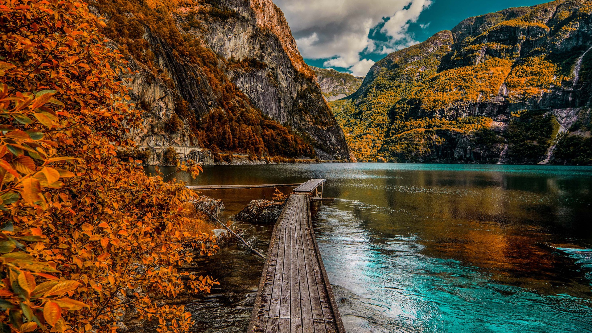 Деревянный мост в воде на фоне гор 