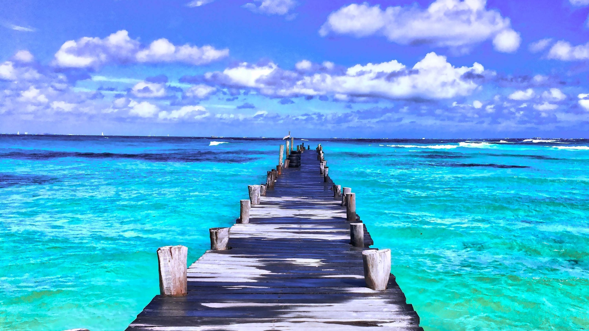 Деревянный мокрый пирс в голубом океане под красивым небом