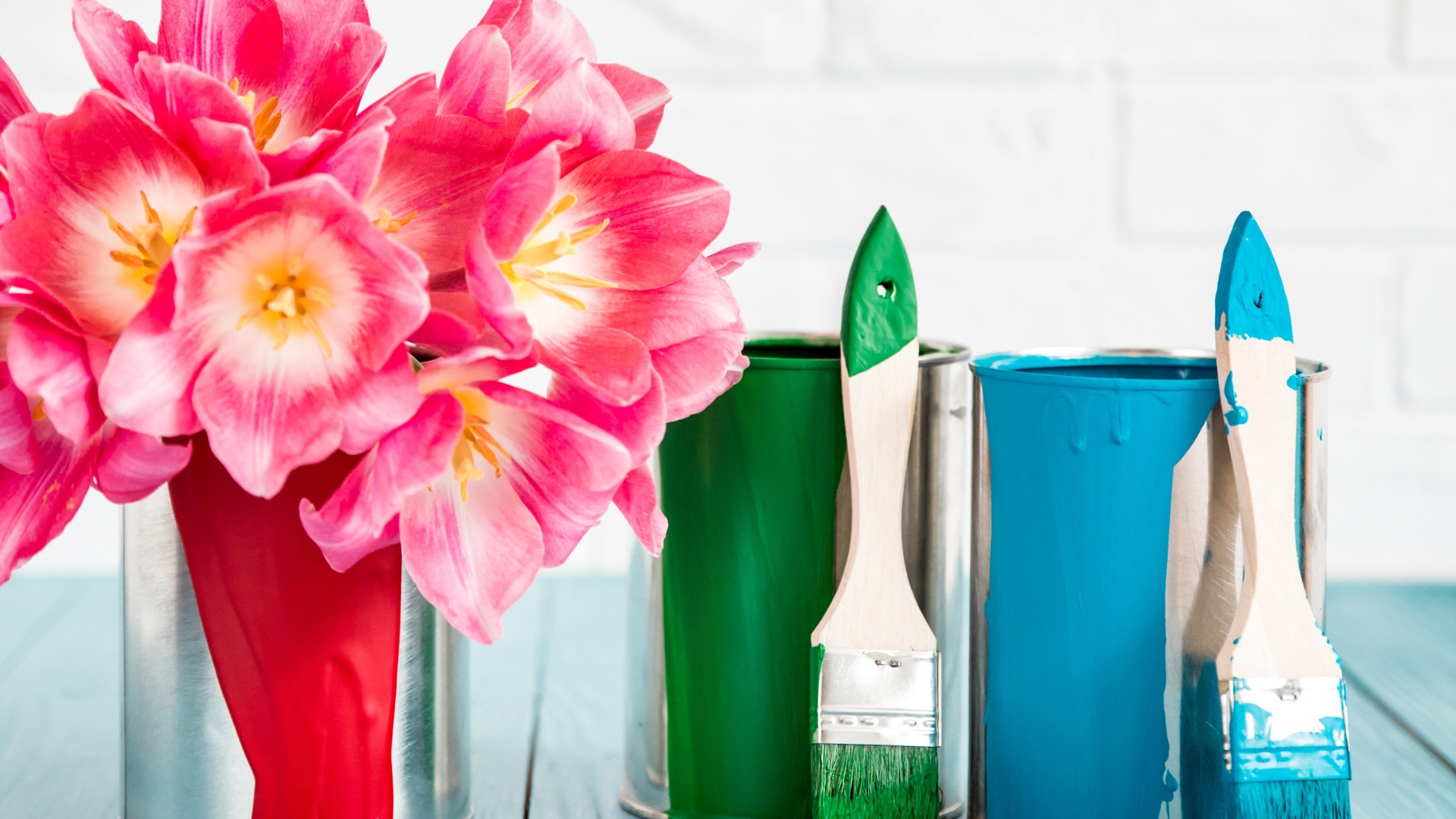 Букет розовых тюльпанов на столе с банками краски и кисточками