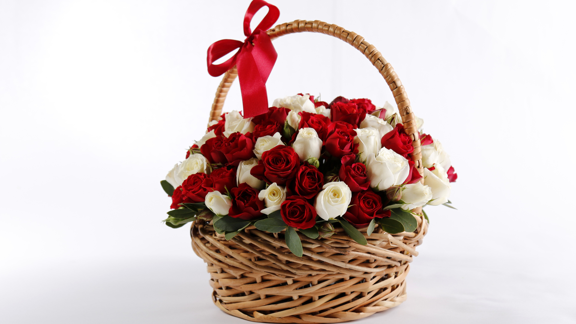 Большой букет роз в корзине в красным бантом на белом фоне