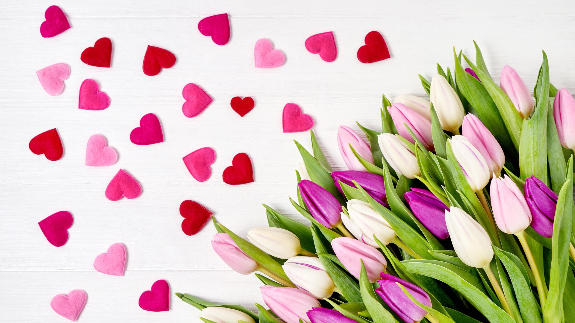 Красивый букет нежных тюльпанов с маленькими сердечками на белом фоне