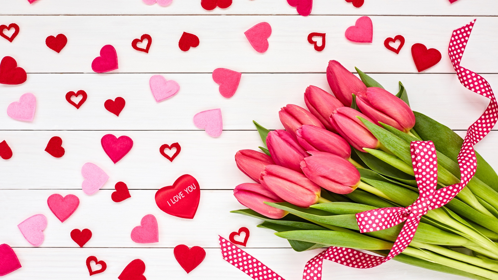 Красивый букет розовых тюльпанов на белом фоне с сердечками и лентой