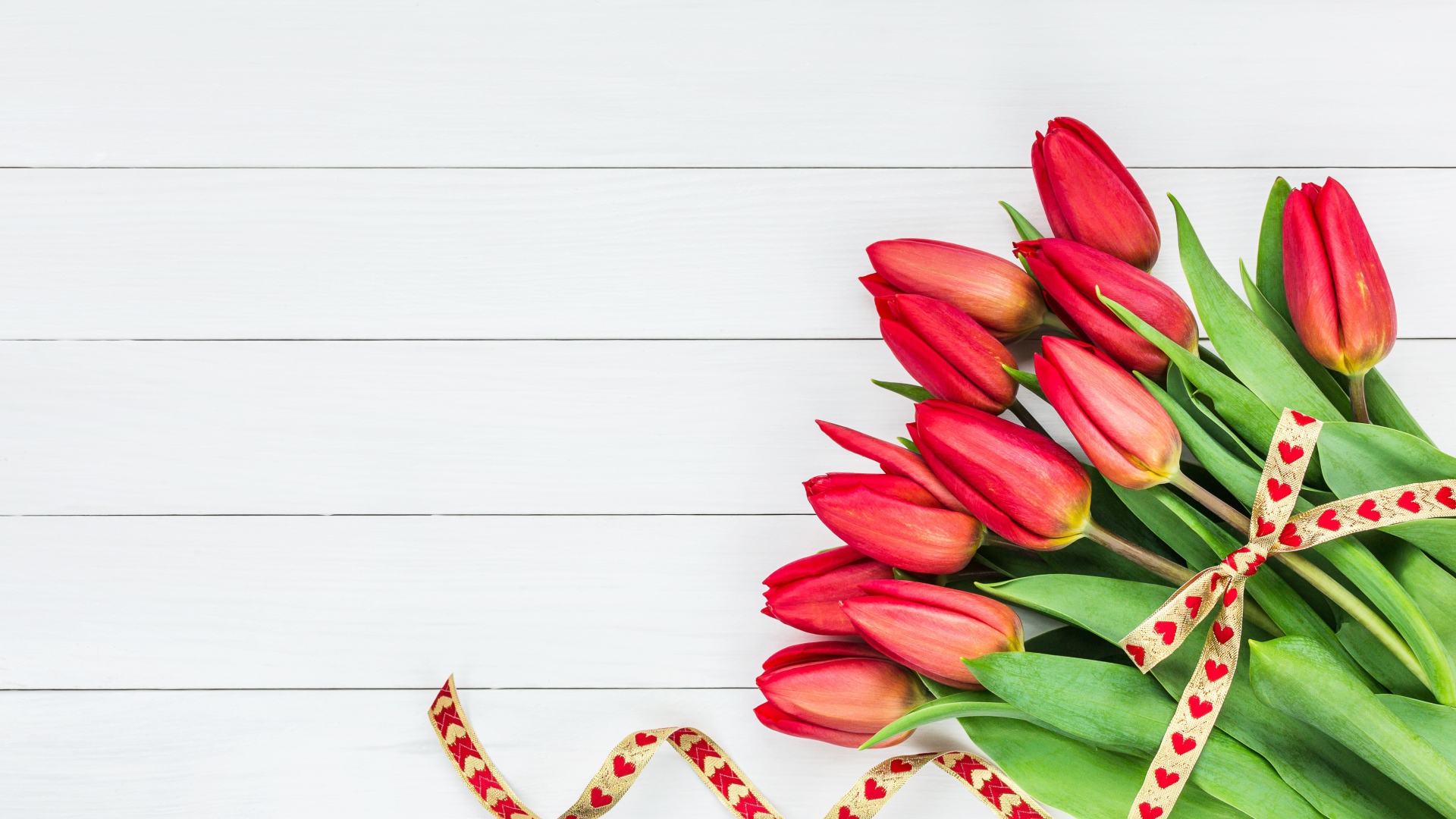 Букет красных тюльпанов с лентой на сером фоне