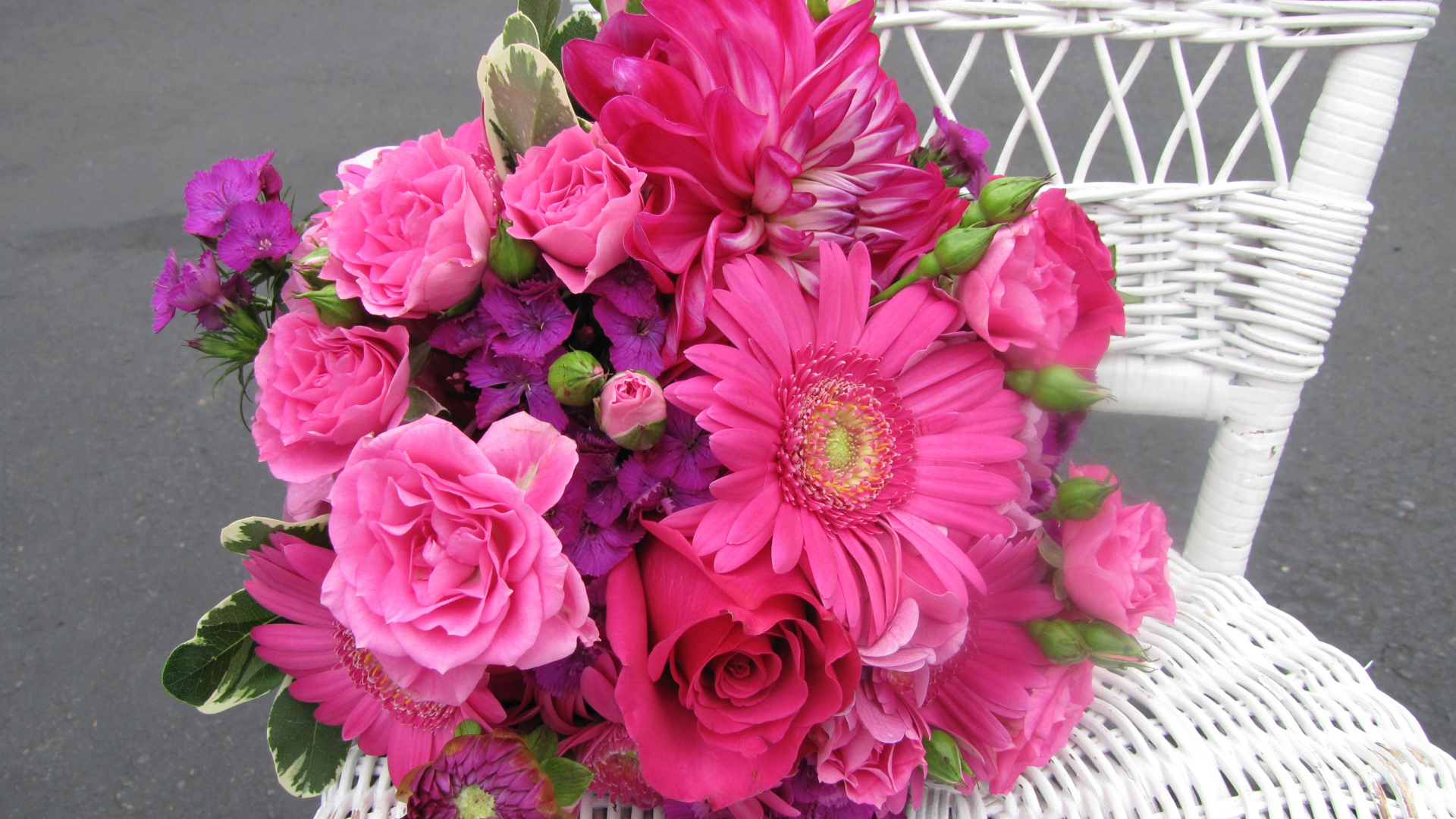 Букет с розовыми цветами георгины, розы, герберы и флоксы на белом стуле