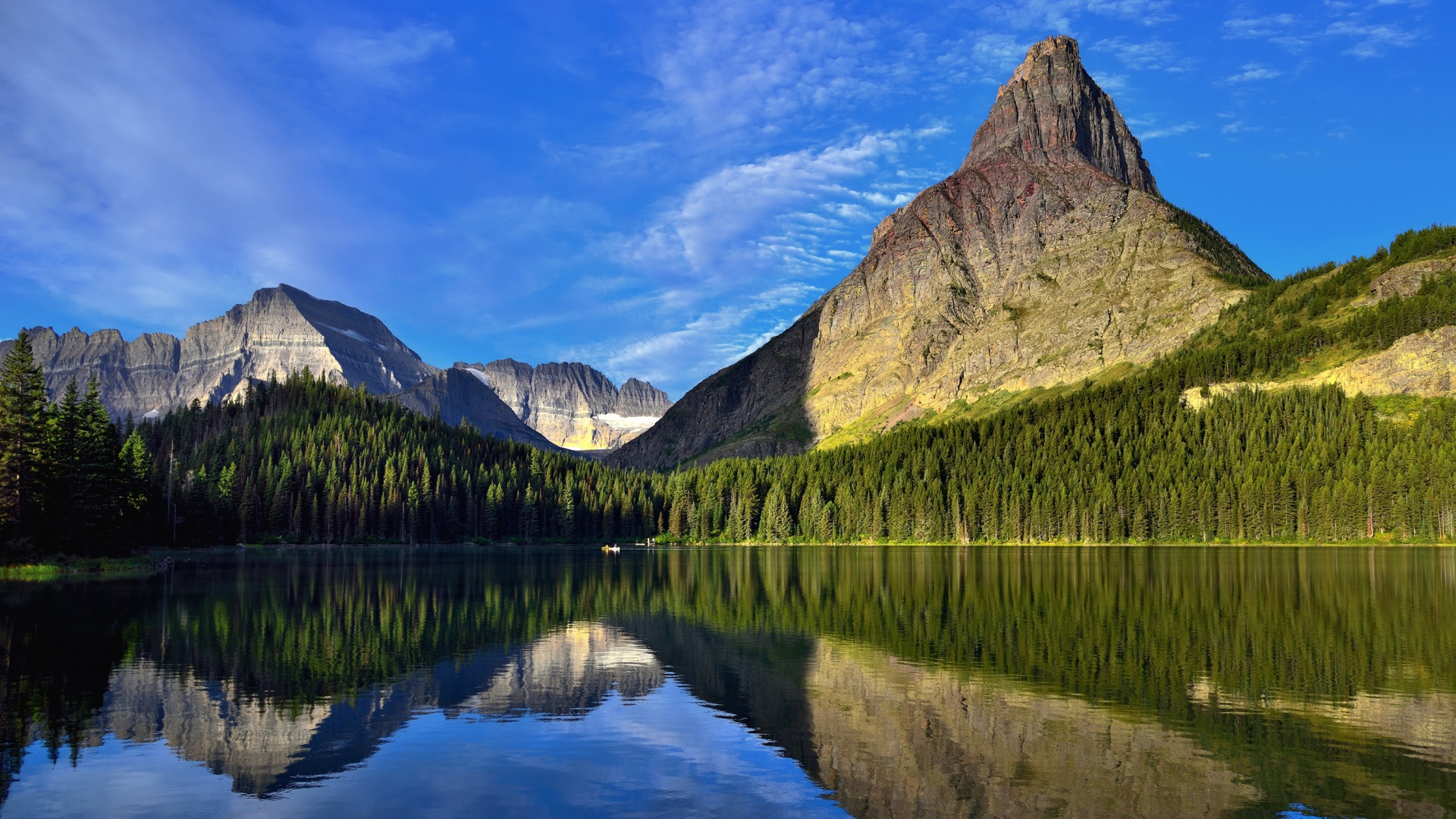 Каменные горы под голубым небом отражаются в воде