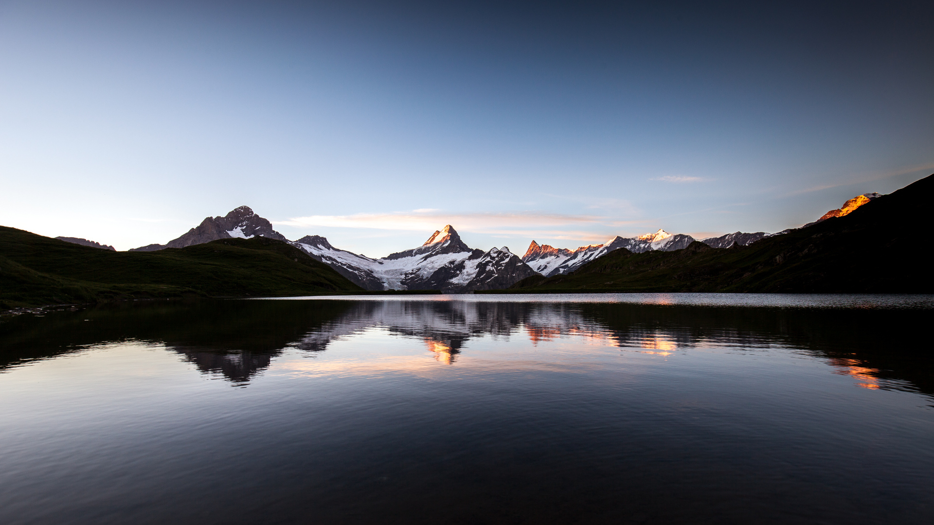 Calm mountain lake near the snowy mountains