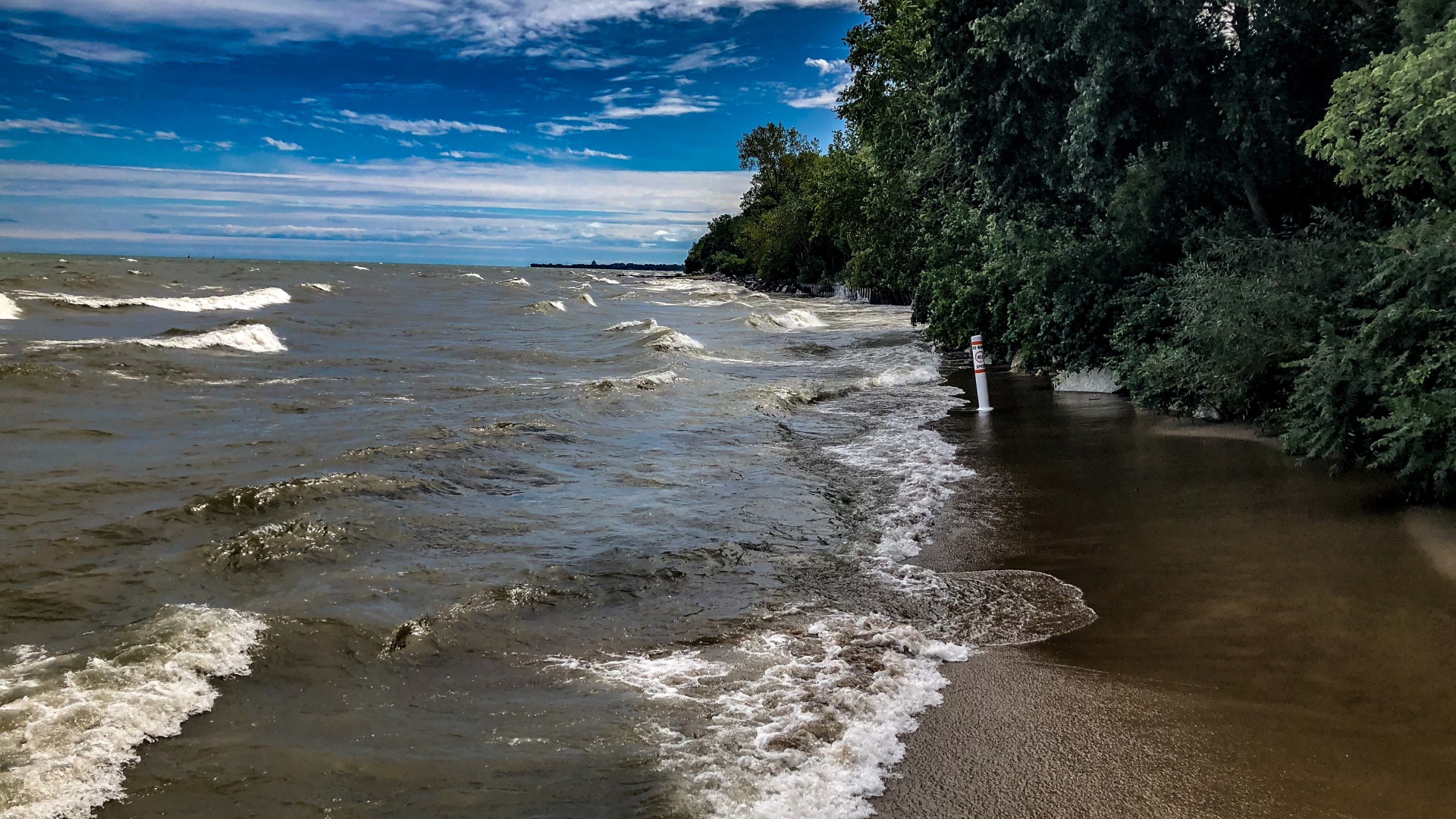 Морские волны омывают берег под голубым небом 