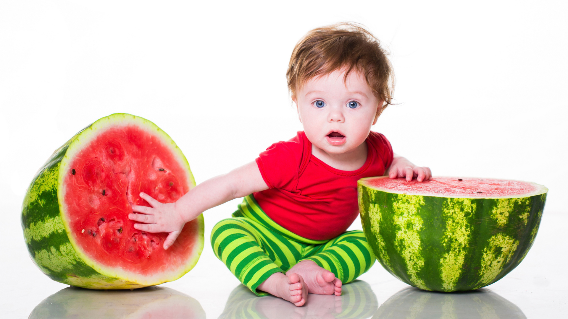 Милый голубоглазый мальчик с арбузом на белом фоне