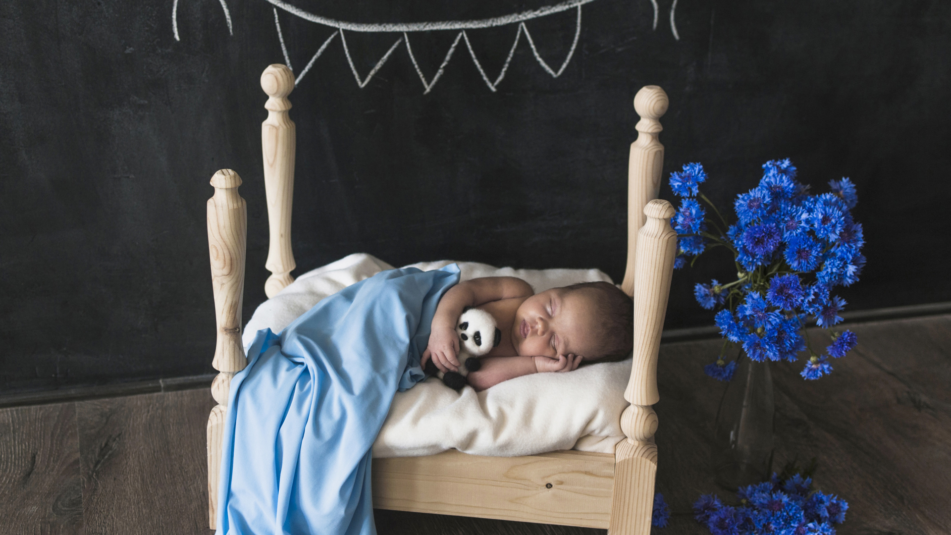 Маленький ребенок спит в деревянной кровати 