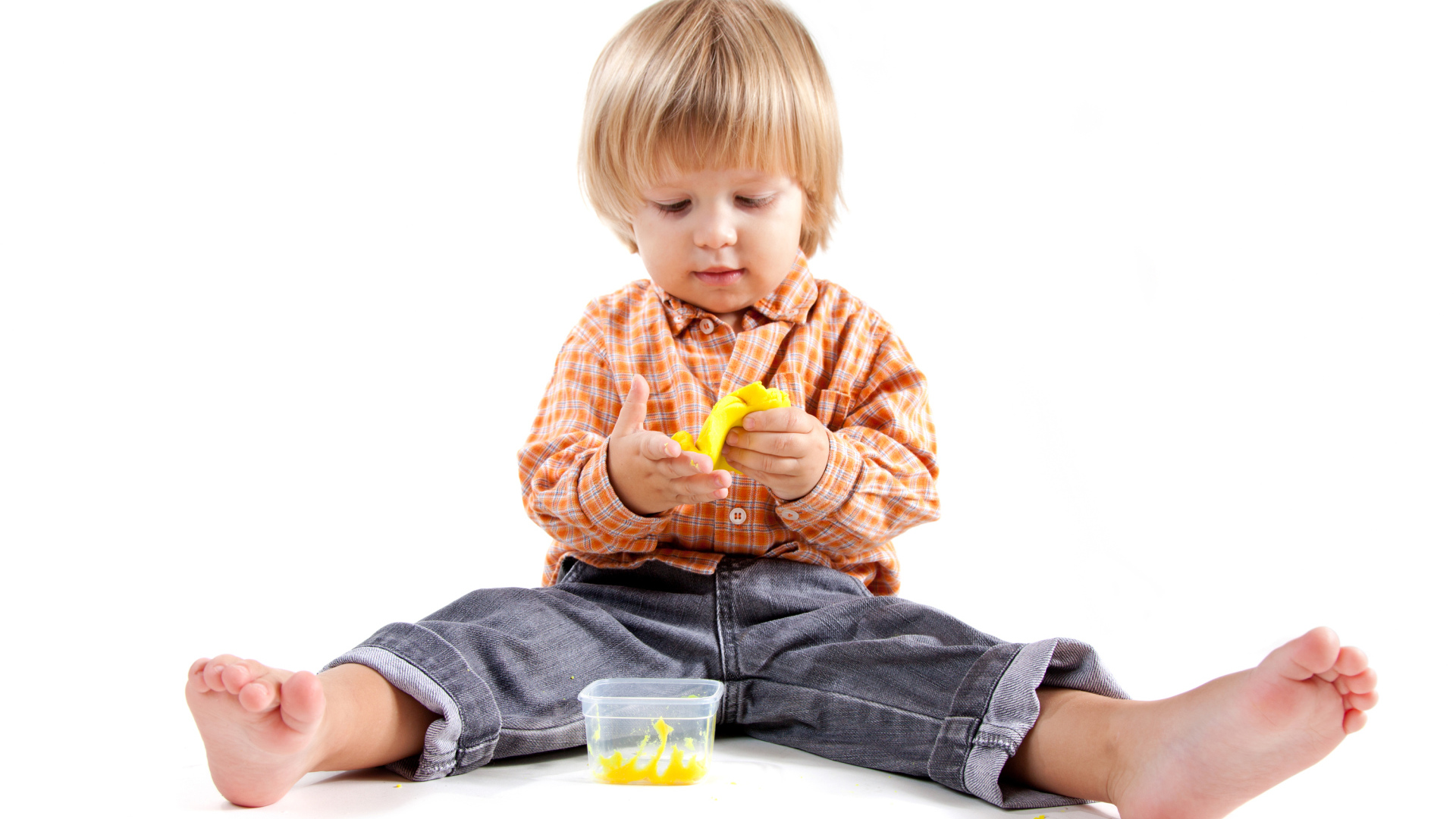 Маленький мальчик с игрушкой на белом фоне